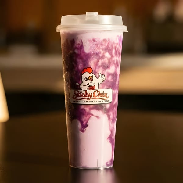A purple and white swirled drink in a clear plastic cup with the Sticky Chix logo.