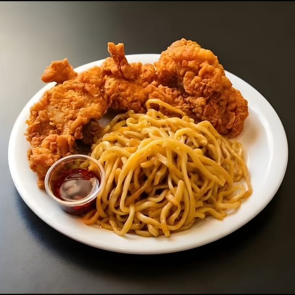 Crispy fried chicken pieces and a pile of noodles with a side of sauce on a white plate.